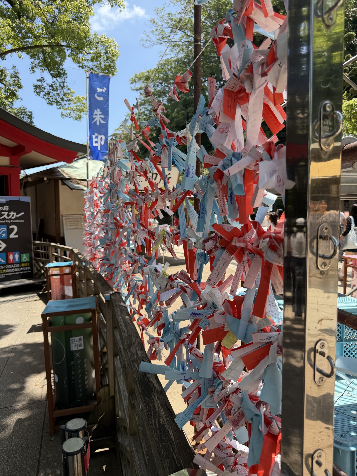 Hundreds of red and blue paper fortunes tied at a shrine